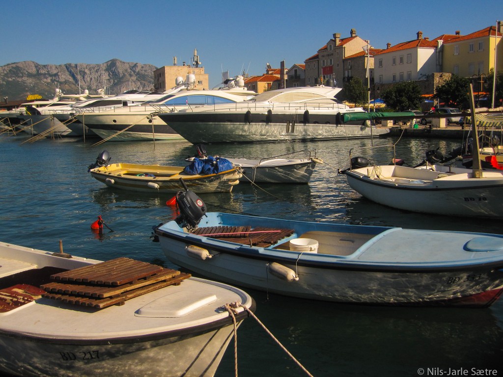 Kontrasten er stor i havnen i Budva.
